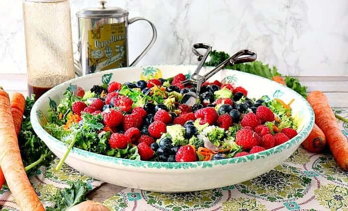 Large bowl with a kale salad with blueberries, raspberries, and blackberries.