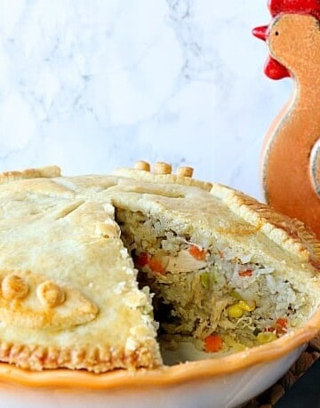 Chicken pot pie with rice and vegetables with a slice taken out.