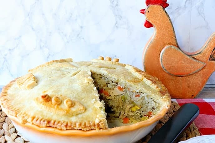 Chicken pot pie with rice and vegetables with a slice taken out.