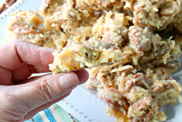 Closeup photo of a coconut pecan praline candy with a bite taken out.