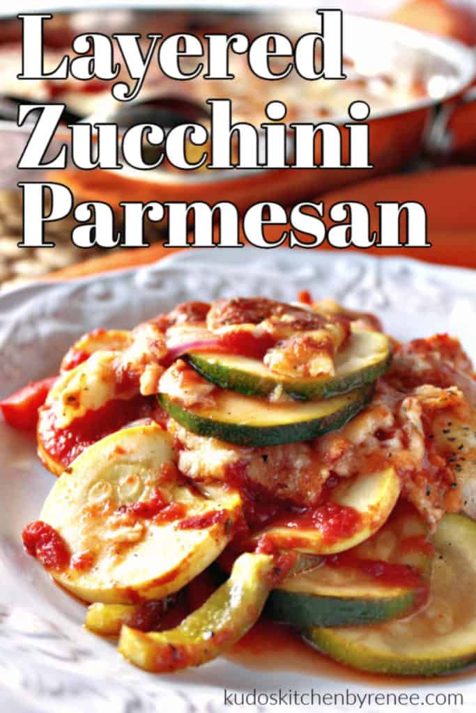 Vertical closeup image of zucchini and summer squash with tomato sauce and parmesan cheese on a white plate.