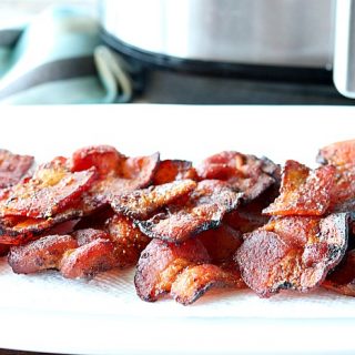 A white plate piled with air fryer bacon.