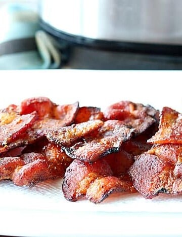 A white plate piled with air fryer bacon.