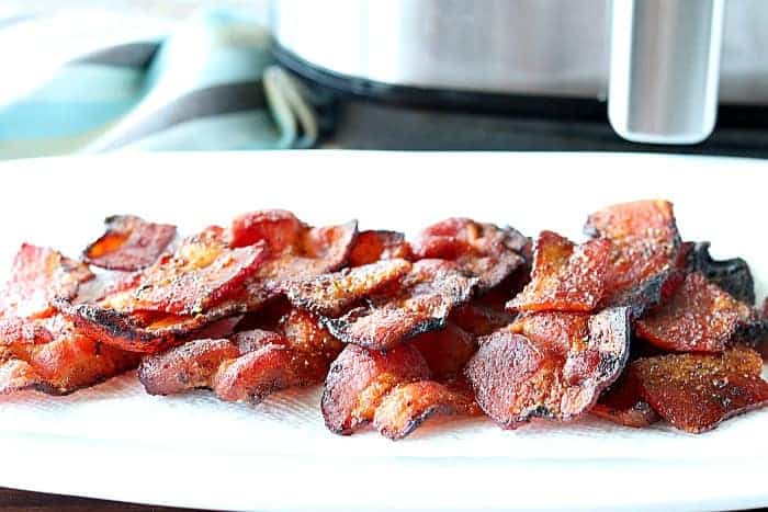 A white plate piled with air fryer bacon.