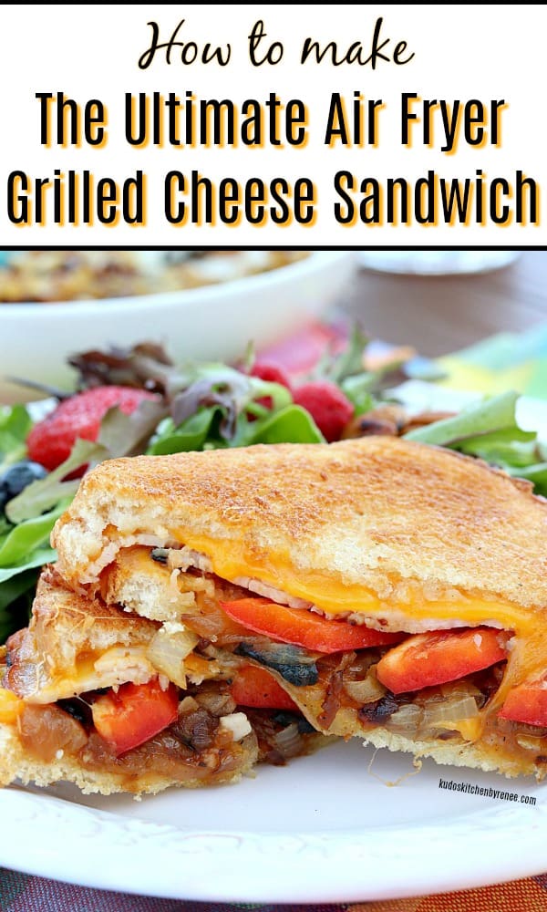 Closeup vertical image of an ultimate grilled cheese sandwich with caramelized onions and red bell peppers on a white plate.