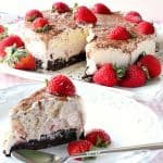 A slice of Neapolitan Ice Cream Cake in the forefront and an entire ice cream cake in the background.