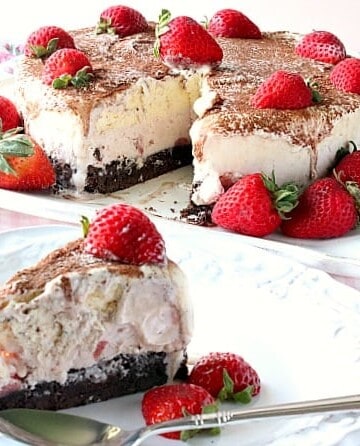 A slice of Neapolitan Ice Cream Cake in the forefront and an entire ice cream cake in the background.