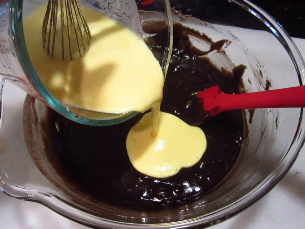 Eggs and butter being added to a Bundt cake batter.