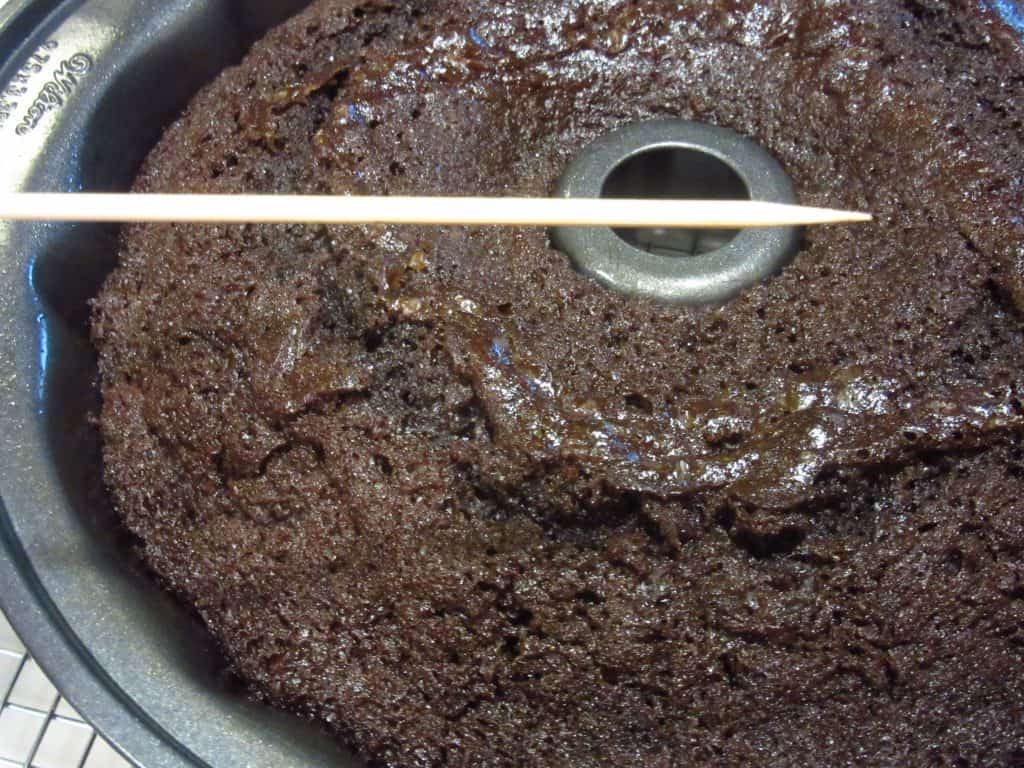 A toothpick coming out clean from a chocolate cherry Bundt cake.