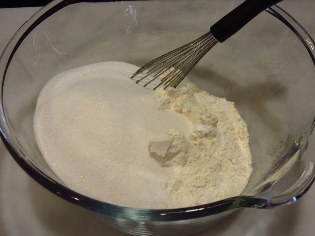 The dry ingredients for making a chocolate Bundt cake in a glass bowl.