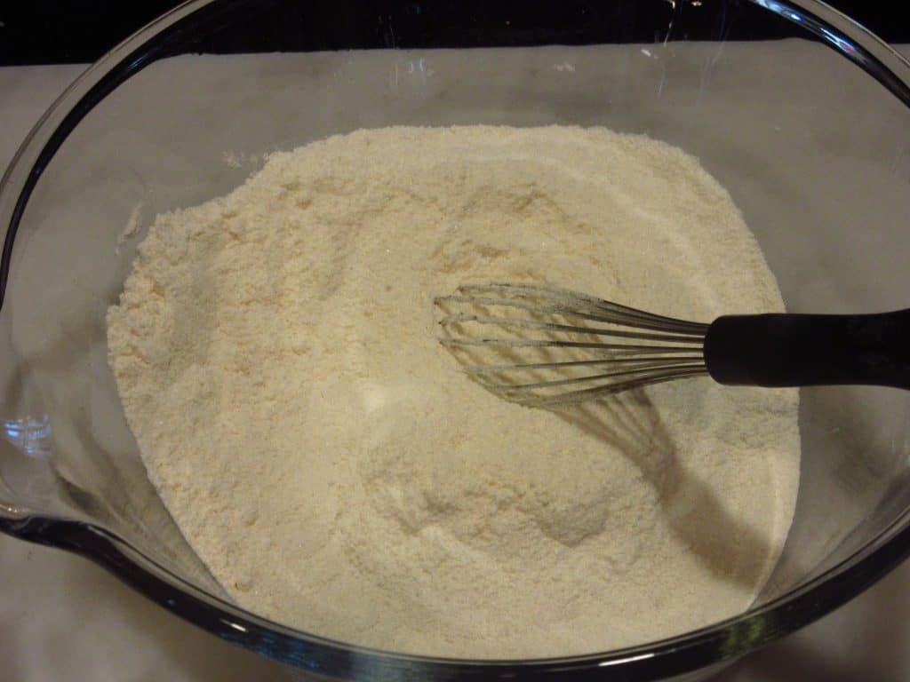 Whisked dry ingredients for making a chocolate Bundt cake in a glass bowl.