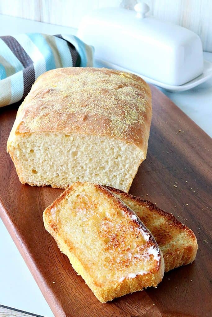 Vertical image of an English muffin bread on a cutting board, sliced and toasted