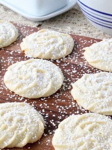 Viennese Whirls Cookies on a wooden board sprinkled with confectioners sugar.
