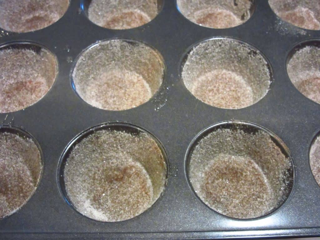 Muffin tins coated with cinnamon sugar.
