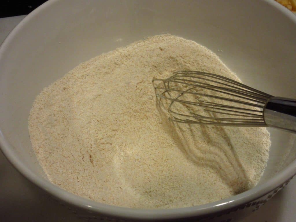 Dry ingredients in a bowl with a whisk.