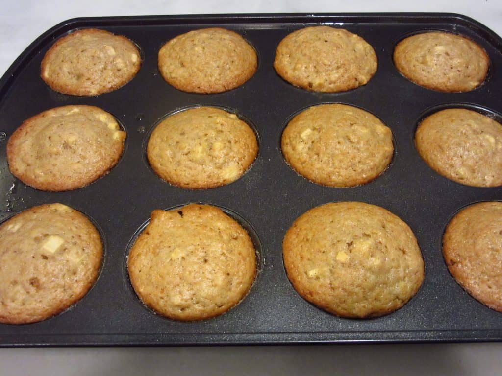 A baked tin of apple cider donut muffins.