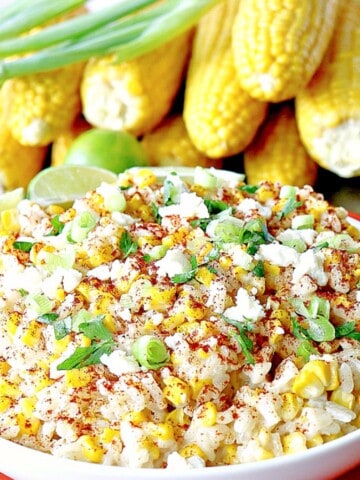 A bowl full of Mexican Street Corn Risotto with cheese and scallions on top.