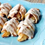 A blue plate holding a few glazed Apple Pie Wedges ready for eating.