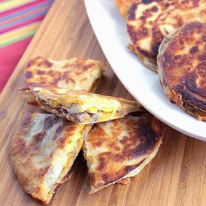 A sliced sausage and Egg Quesadilla on a wooden board.