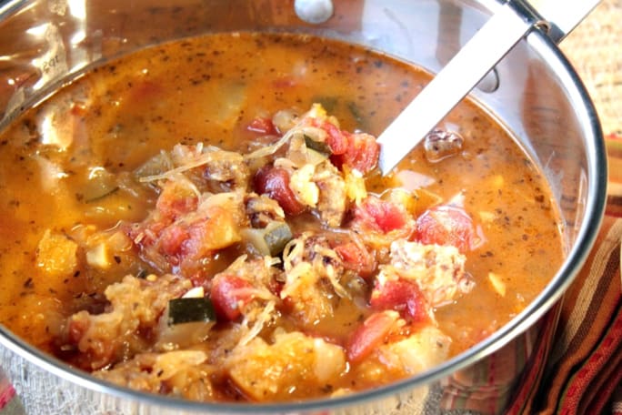 A horizontal photo of a look inside a stockpot filled with spaghetti squash soup and a ladle.