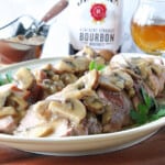 Sliced Pork Tenderloin with Mushroom Bourbon Gravy on a platter.