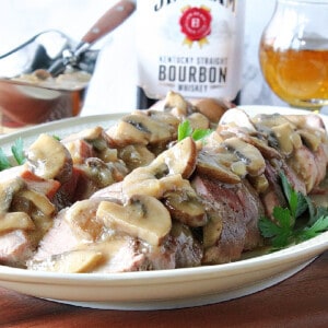 Sliced Pork Tenderloin with Mushroom Bourbon Gravy on a platter.