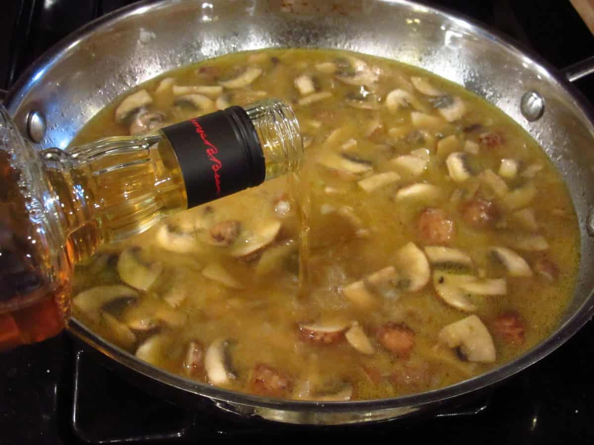 Bourbon being added to mushroom gravy.