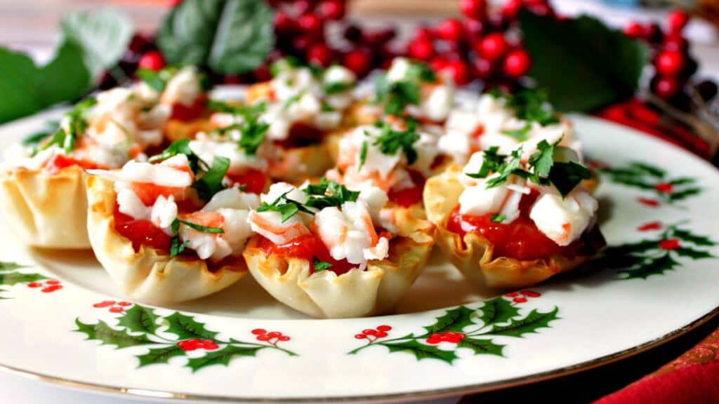 A festive plate filled with Shrimp Cocktail Appetizer Bites with red and green holiday accents.
