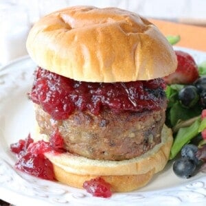 A Stuffing Stuffed Turkey Burger topped with cranberry sauce and a bun.