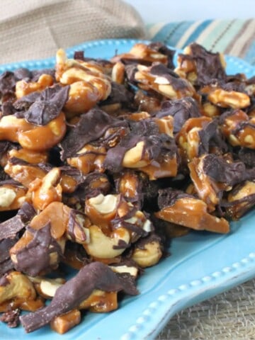 A blue plate loaded with Butter Toffee Cashew Crunch.