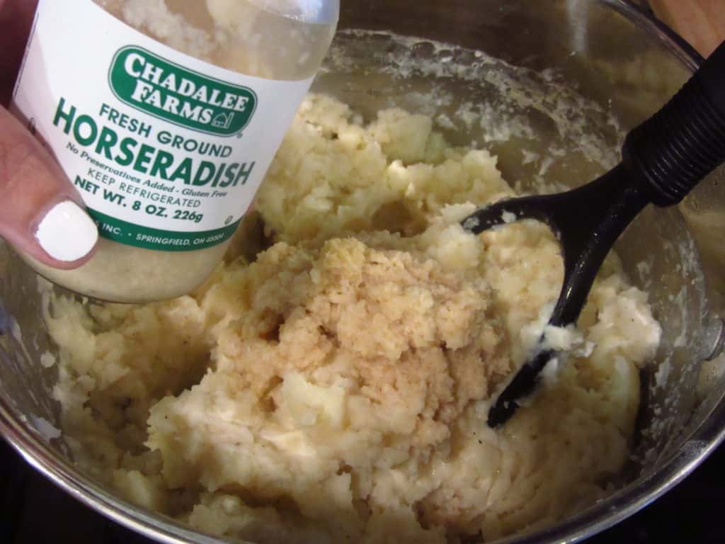 A jar of horseradish and a pot of mashed potatoes.
