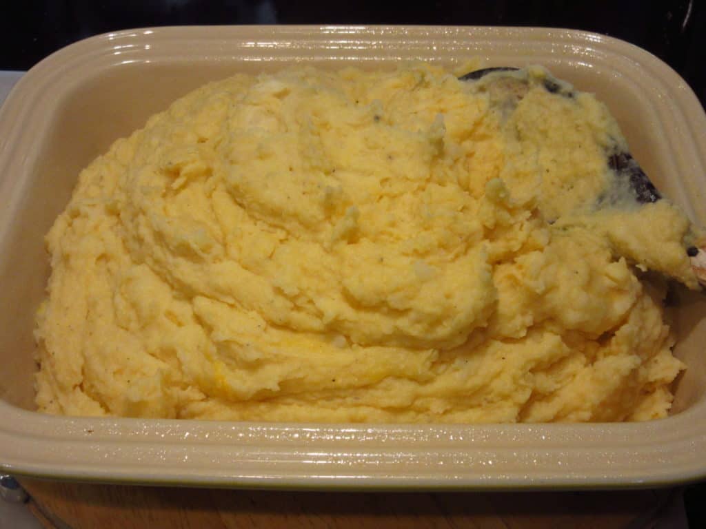 A pile of cheesy horseradish mashed potatoes in a casserole dish.