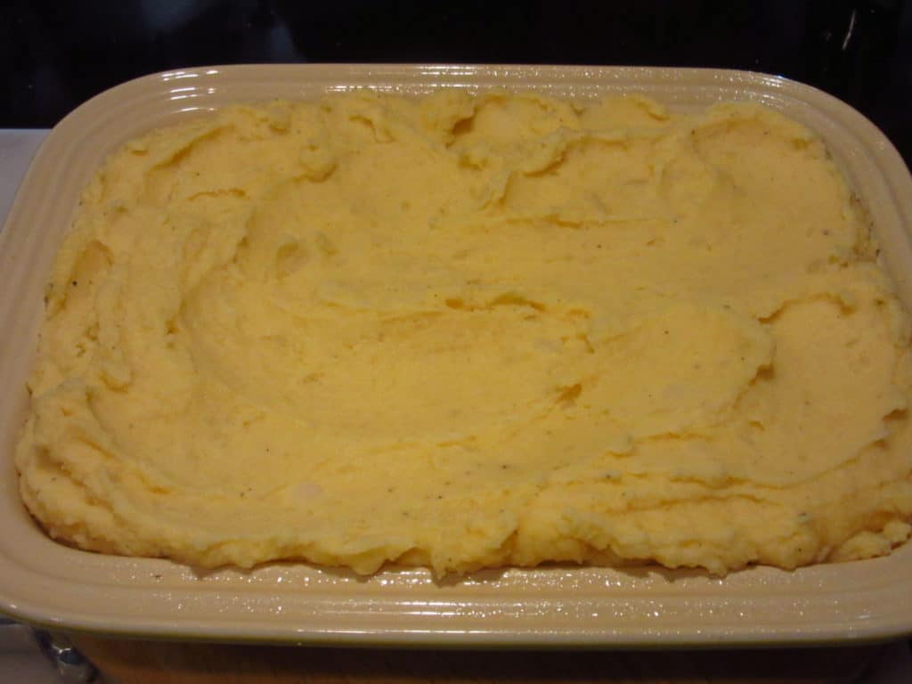 An unbaked casserole dish of mashed potatoes.