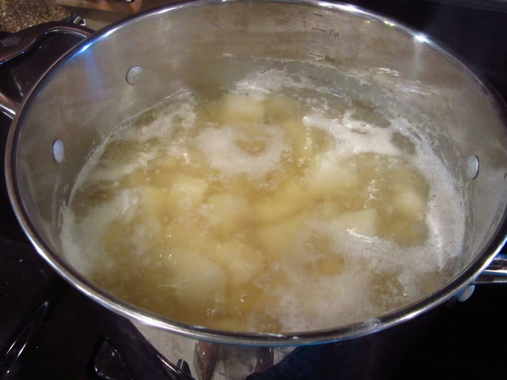 Potatoes boiling in a pot of water.