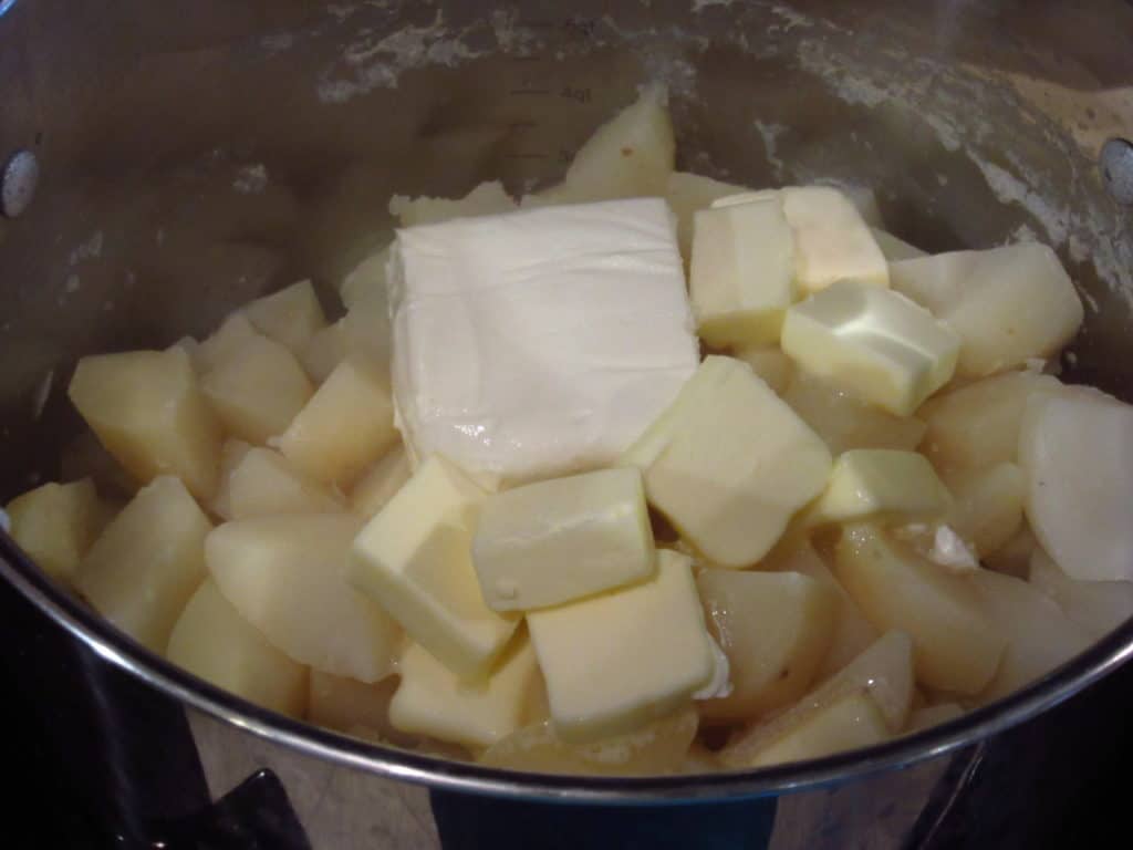 Cooked potatoes with butter and cream cheese in a pot.