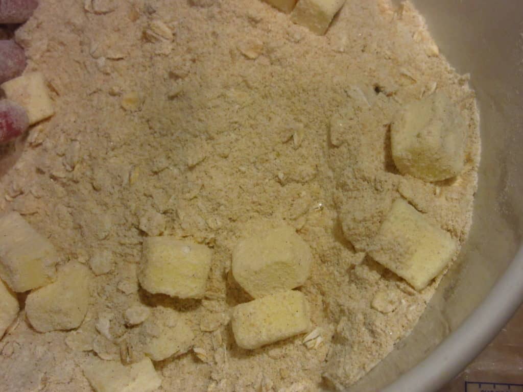 Butter pieces added to a bowl of dry ingredients.