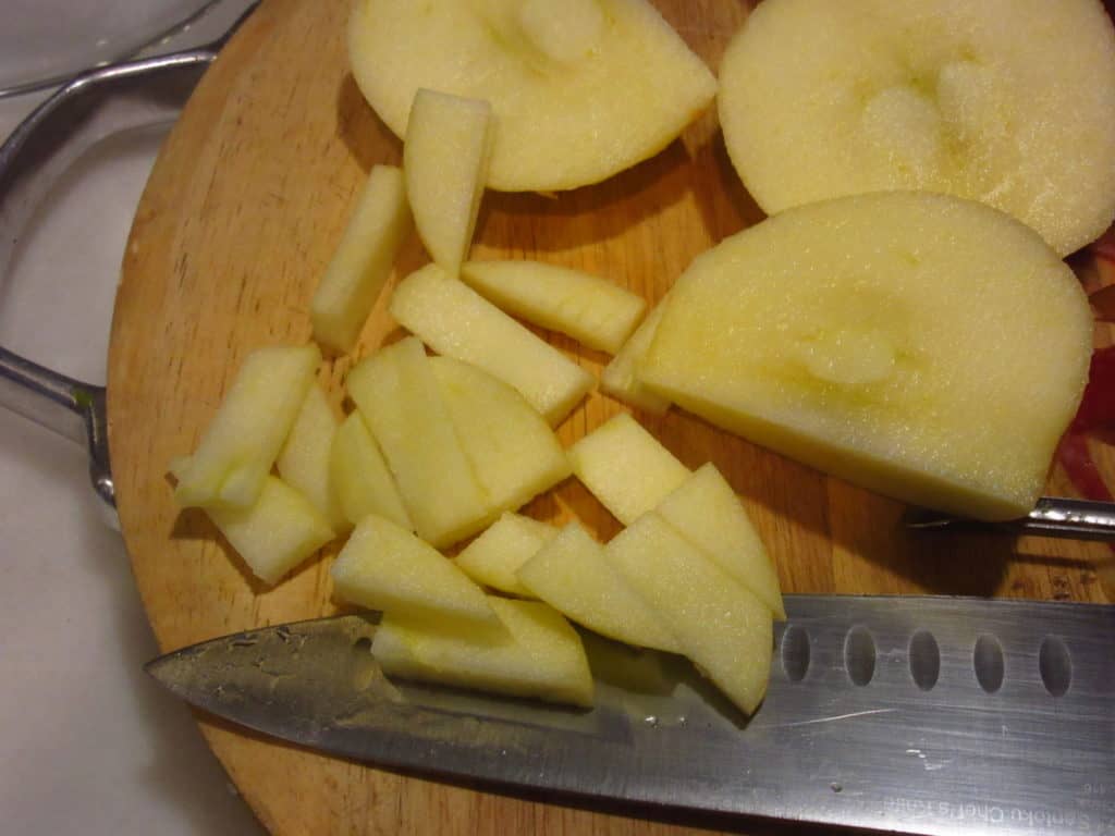 Apples being diced on a cutting board.