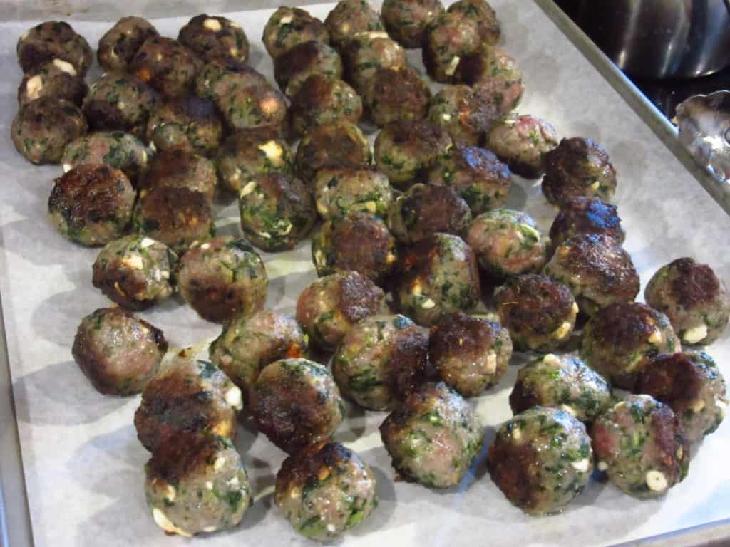 Greek meatballs on a baking sheet.