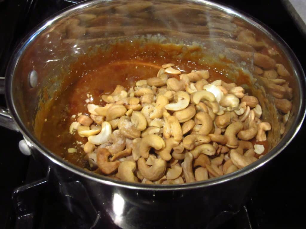 Cashews added to a saucepan making toffee.