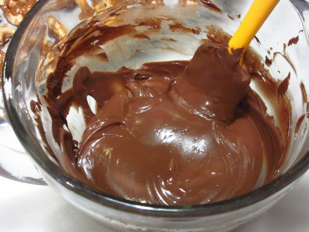 Smooth melted chocolate in a glass bowl.