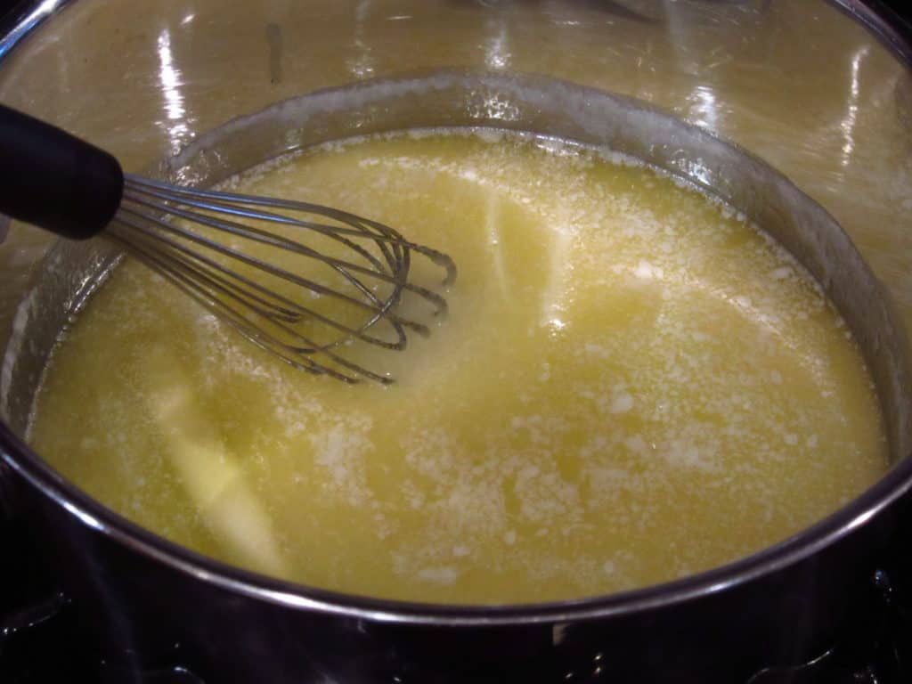 Melted butter and a whisk in a saucepan.