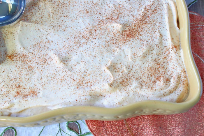 Abaking dish filled with pumpkin ice cream sprinkled with cinnamon.