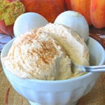 A scoop of Pumpkin Pie Ice Cream in a white bowl with a spoon.