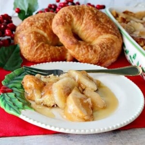 A festive Christmas plate with a serving of Apple Croissant Breakfast Bake and a fork.