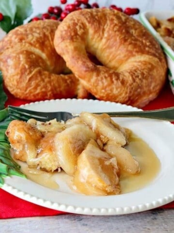 A festive Christmas plate with a serving of Apple Croissant Breakfast Bake and a fork.