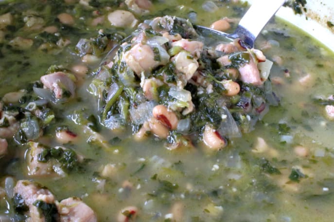 Closeup horizontal photo of healthy family dinner of black eyed pea chicken chili with spinach.