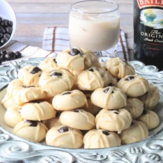A decorative round plate filled with Irish cream butter cookies with chocolate covered espresso beans