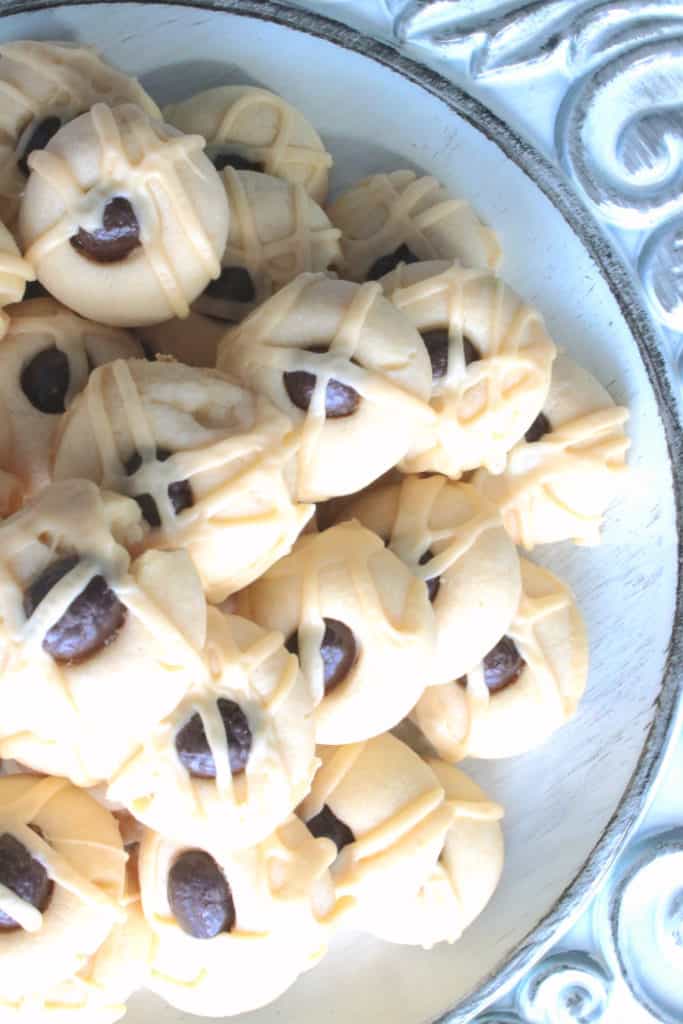 Closeup overhead offset photo of a found plate of Irish cream butter cookies with a glaze and chocolate covered espresso beans.