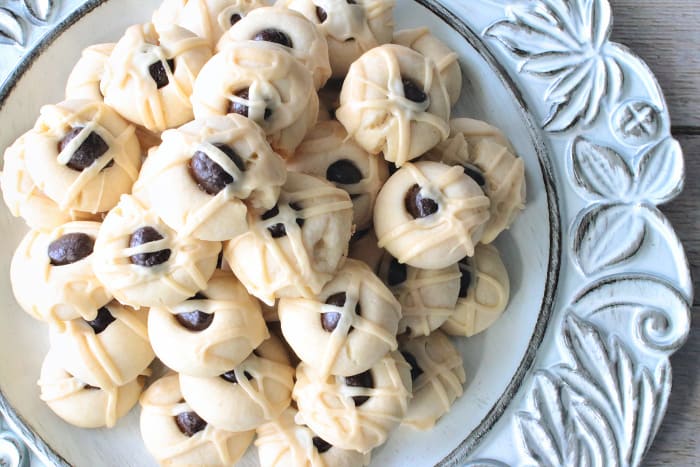 A pretty blue plate filled with Irish butter cookies with expresso beans on top.