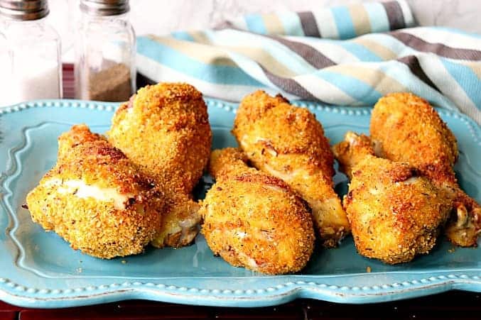 A horizontal photo of a blue rectangle plate filled with crispy chicken drumsticks.